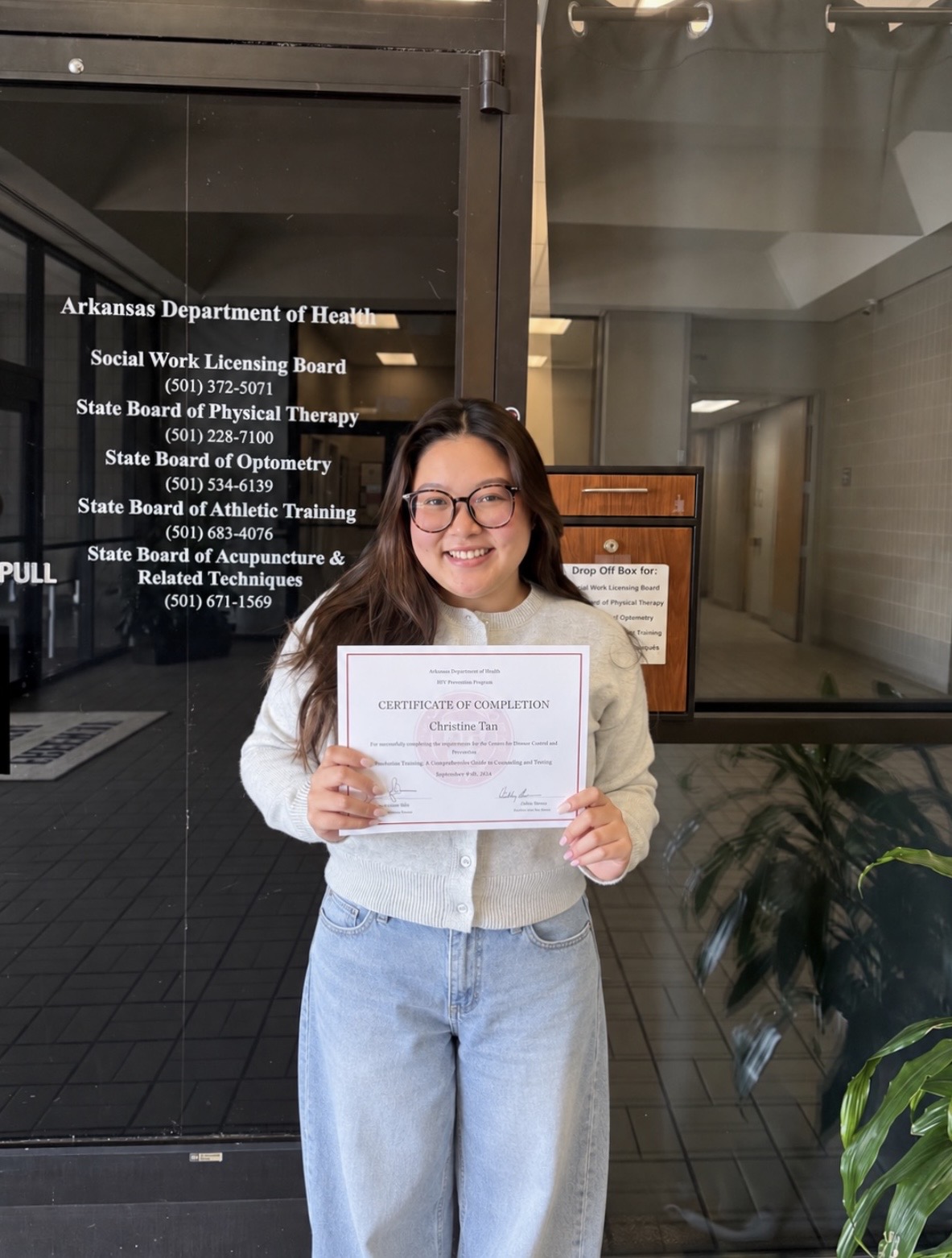 Christine Tan holding her Arkansas Department of Health syndemic training certificate of completion