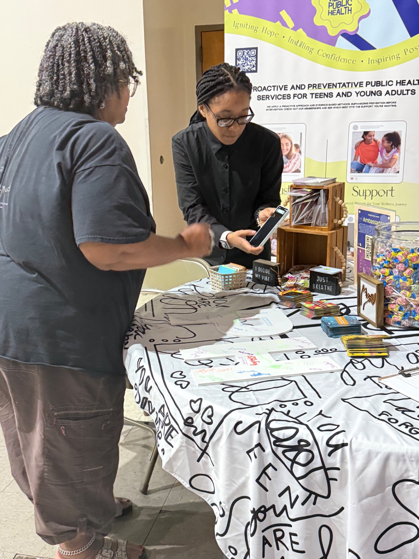 Helping a visitor sign up at the Village Public Health resource table