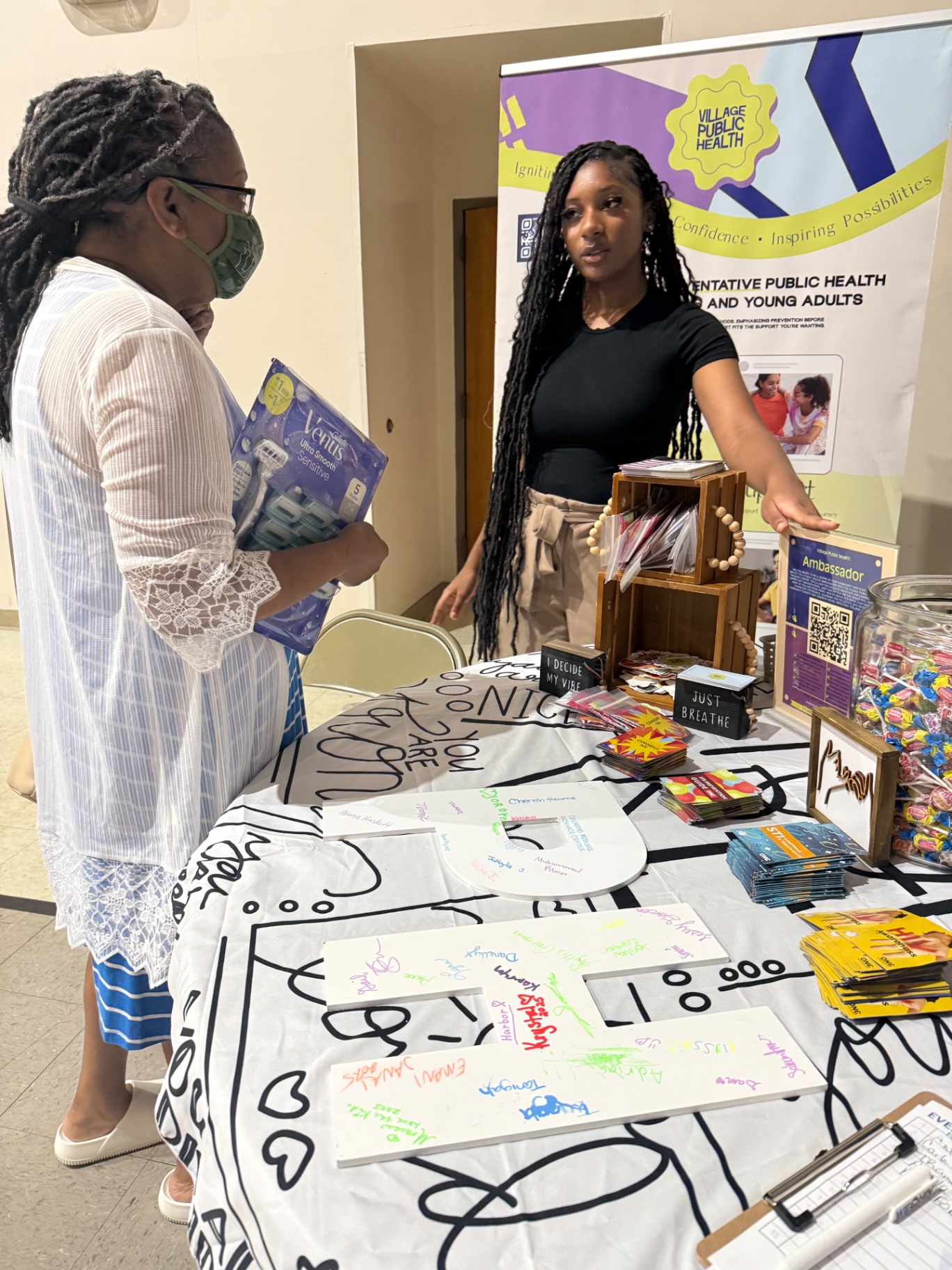 Team member sharing resources with a community member at the Village Public Health table